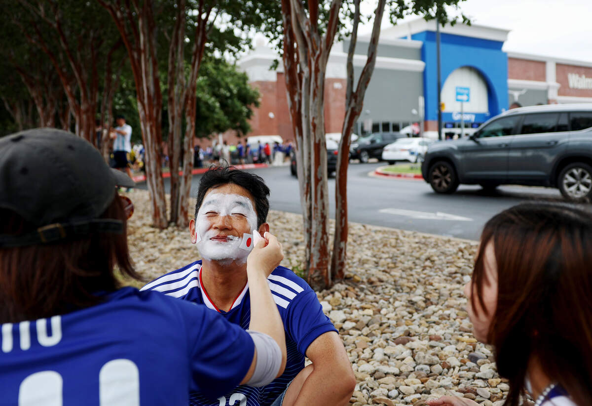Japan fans prepare for the FIFA World Cup 2026 group stage matchup against Sweden by painting their faces at a nearby Walmart parking lot on Thursday, June 25, 2026, in Arlington.